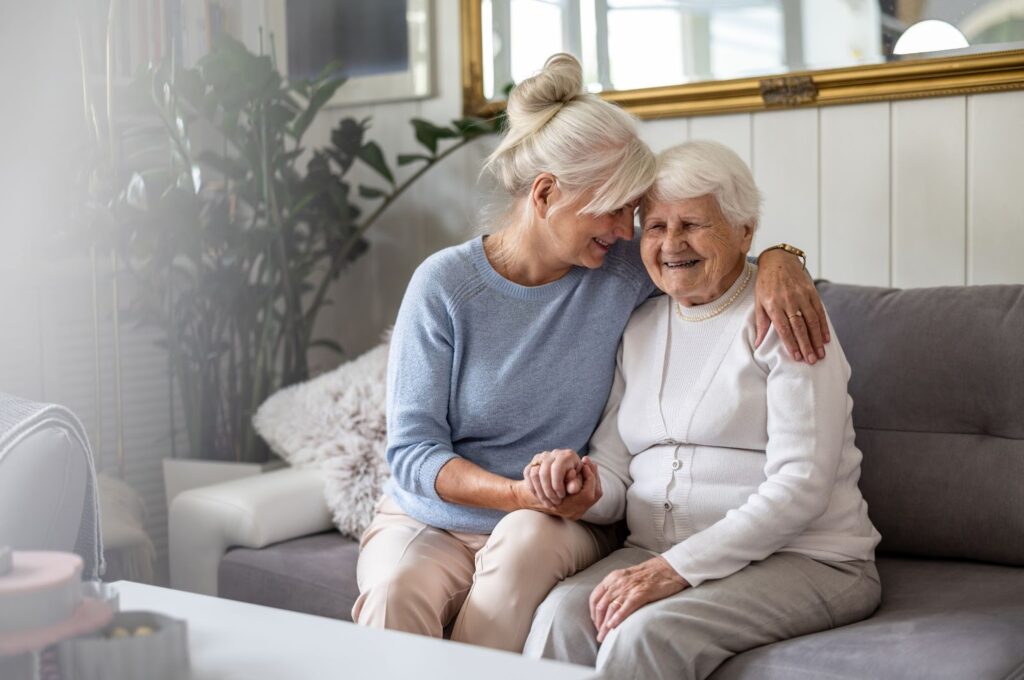 A daughter embraces her mature mother while visiting her loved one in memory care.