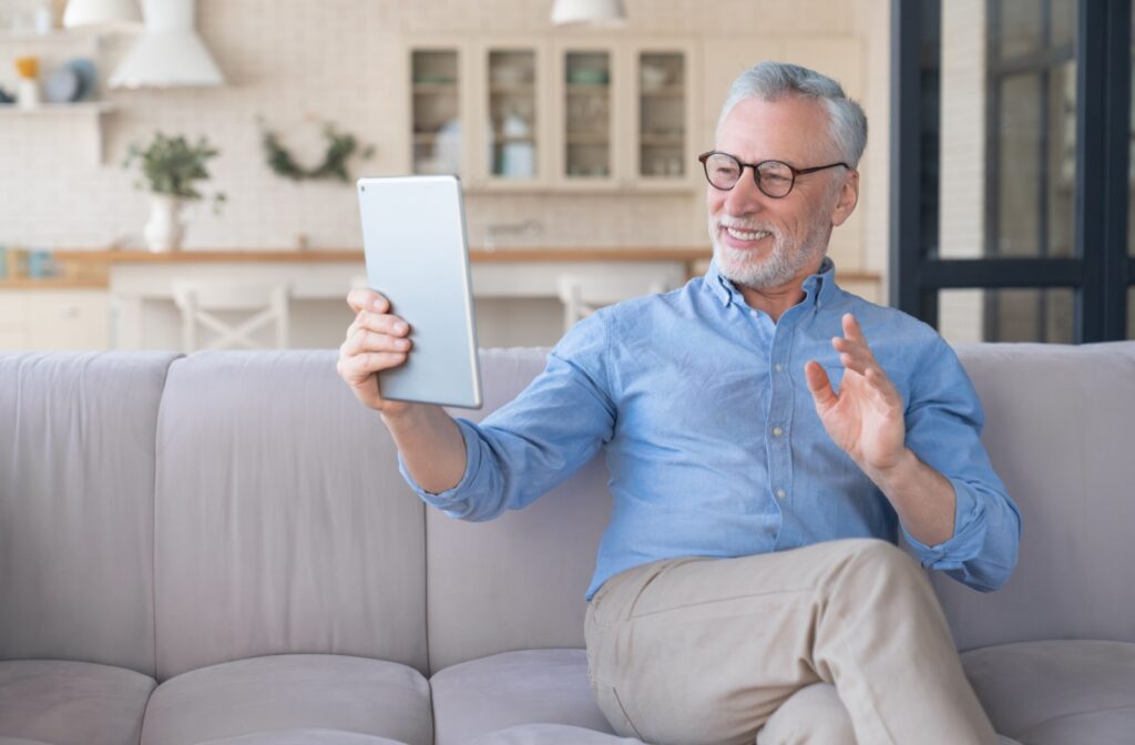 An elder man using his ipad to connect with his family.